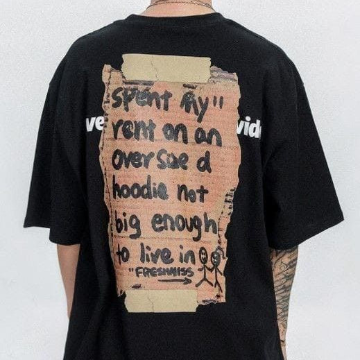 Dark-colored oversize t-shirt with a graphic resembling a torn paper note containing handwritten text, including "spent my rent on a hoodie not big enough to live in" and "FRESHNESS," on the back.