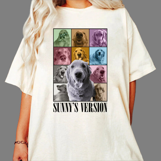 A light-skinned person with long blonde hair wears an off-white t-shirt with a colorful dog photo collage.