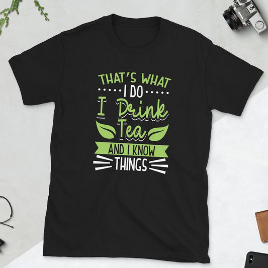 Black t-shirt with "That's What I Do I Drink Tea And I Know Things" in green and white lettering. A humorous design for tea enthusiasts.