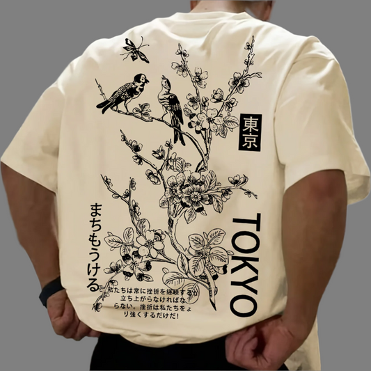 Light-colored oversize t-shirt with a graphic of birds on a flowering branch, "Tokyo" text in English and Japanese, and additional Japanese text on the back.