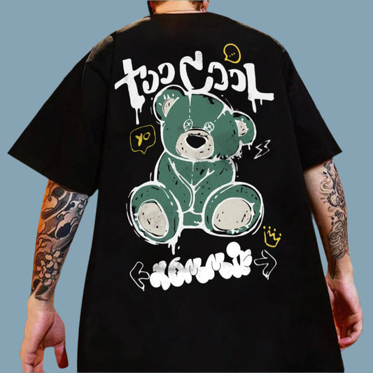Dark-colored oversize t-shirt with a "Too Cool" text graphic, a teddy bear illustration, and various doodle-like accents on the back.