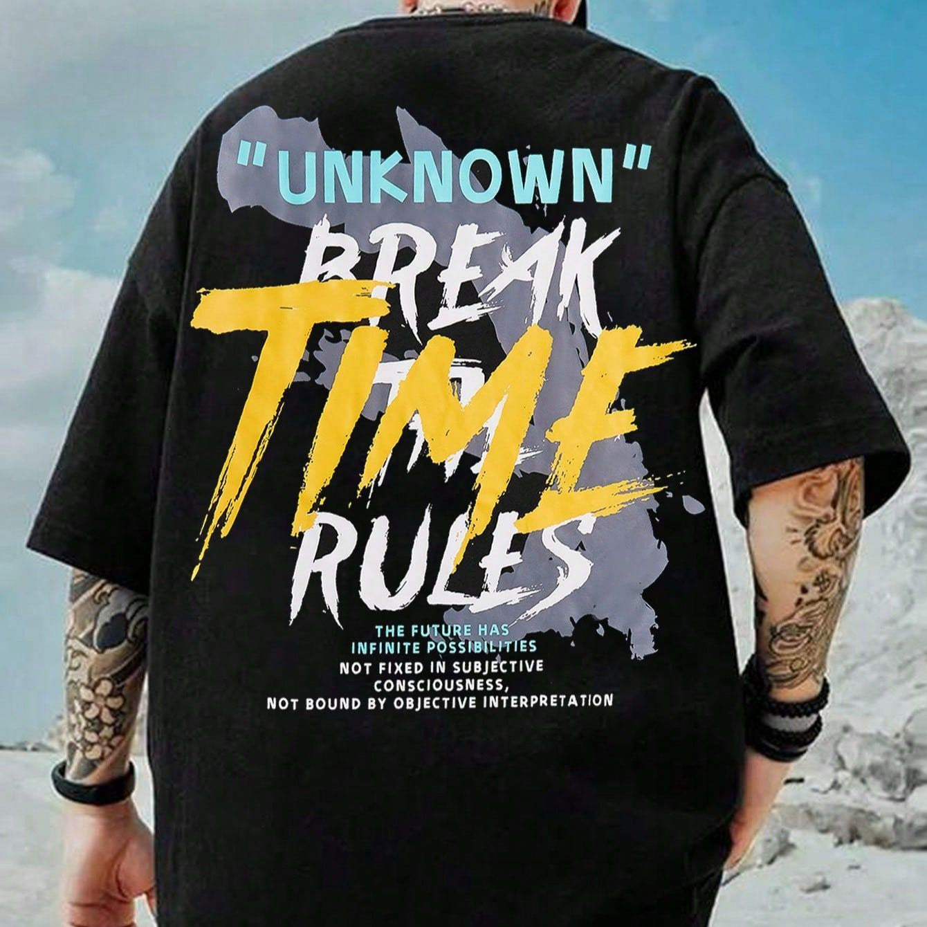 Dark-colored oversized t-shirt with "Unknown" and "Break Time Rules" graphics on the back, along with text and abstract shapes.
