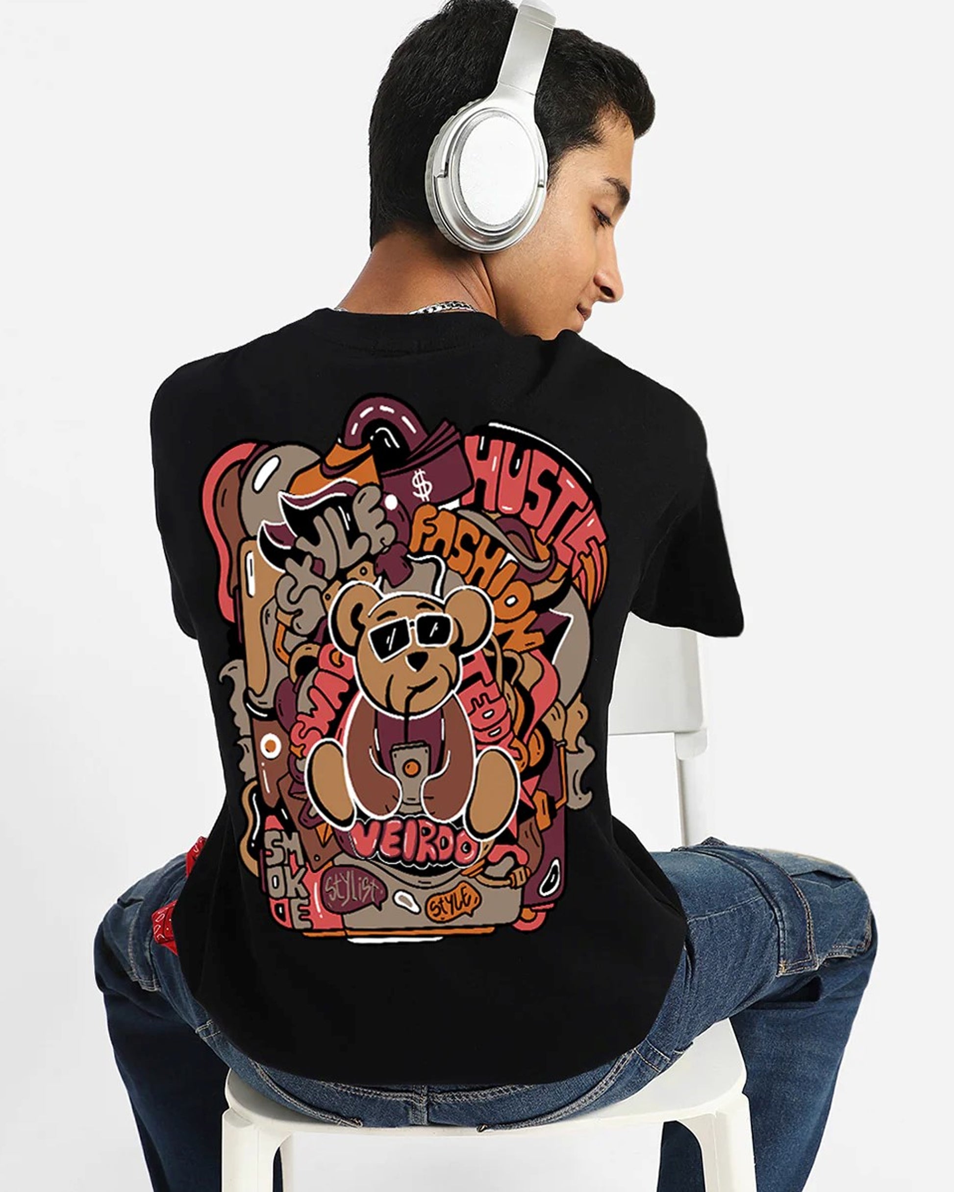  Black t-shirt with a cartoon bear and graffiti-style graphics, worn by a young man.