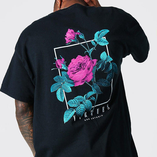 Dark-colored oversized t-shirt with a detailed rose graphic in shades of pink and blue on the back, enclosed in a white square outline. The text "Virtues San Antonio" is visible below the graphic.