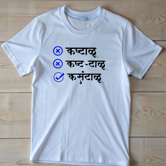  White t-shirt with blue checkboxes and Marathi words "कष्टाळू" (hardworking), "कष्ट-टाळू" (avoiding hard work), and a checked "कमवटाळू" (earning avoider).