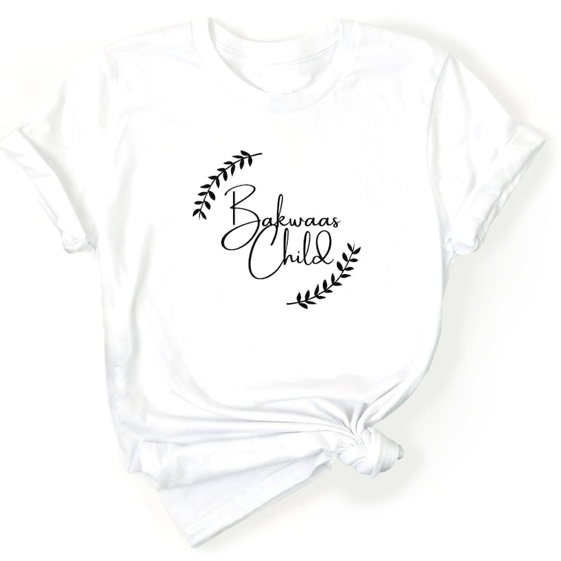 White t-shirt featuring the text "Bakwaas Child" in a stylish font, accompanied by leaf graphics.