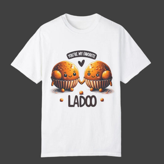 White t-shirt with two cartoon-like ladoos holding hands, the phrase "YOU'RE MY FAVORITE" in a speech bubble, and the word "LADOO" below them. Cotton blend t-shirts, available in various sizes.