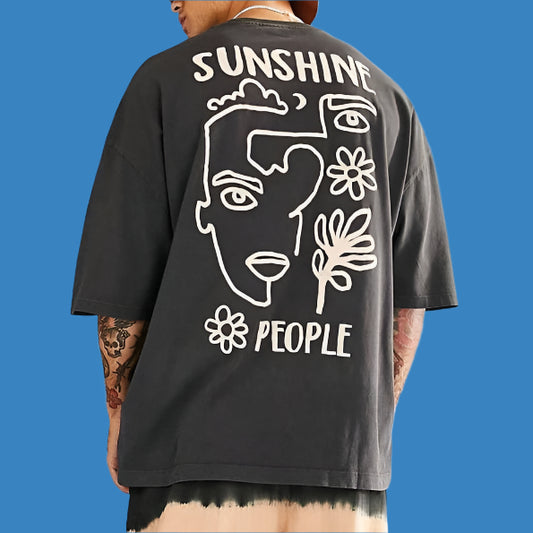 Dark-colored oversize t-shirt with "Sunshine" and "People" text, along with abstract line art of a face and flowers on the back.