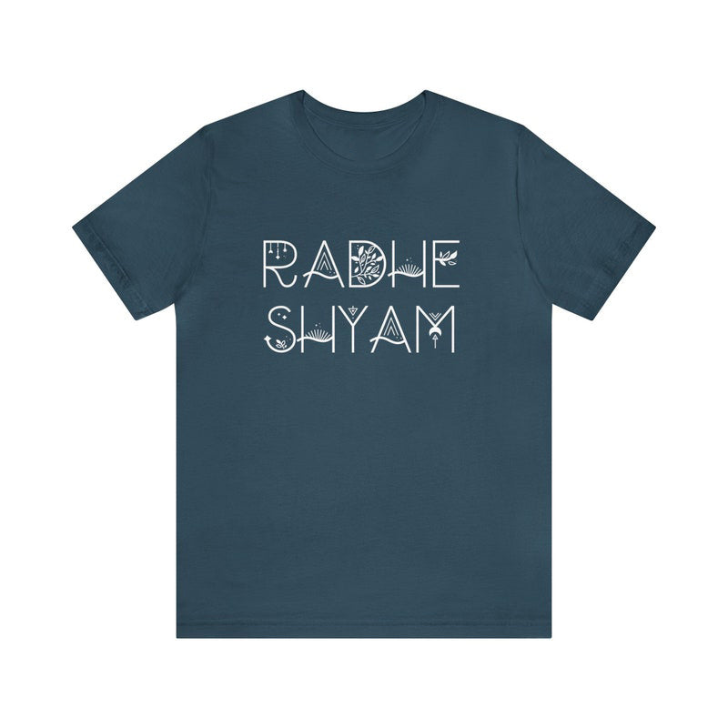 Dark teal t-shirt with the words "Radhe Shyam" in a stylized white font with subtle botanical line art integrated into the letters.