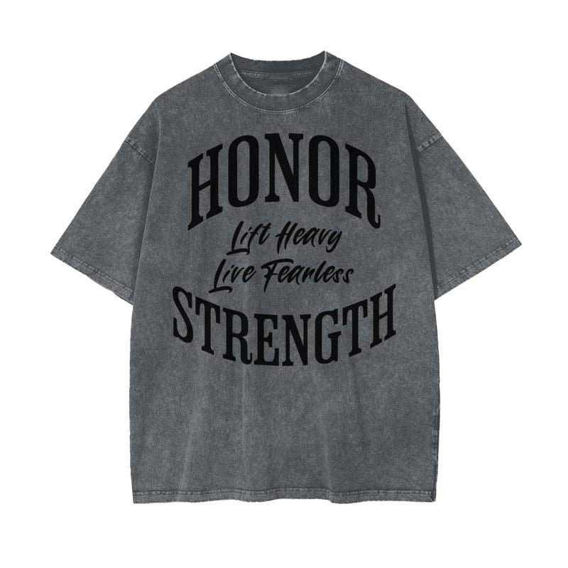 A gray t-shirt with "Honor," "Lift Heavy," "Live Fearless," and "Strength" in bold black lettering.