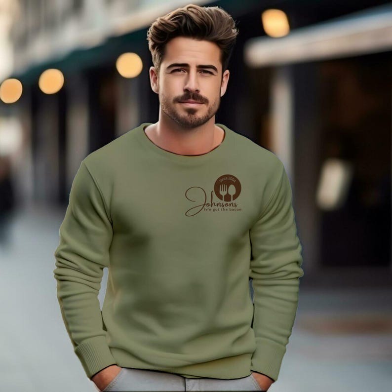 man stand close olive green sweatshirts with a small logo on the chest.