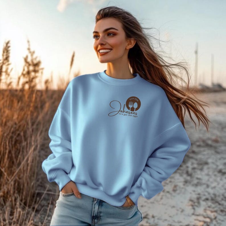 woman stand close light blue sweatshirts with a small logo on the chest.
