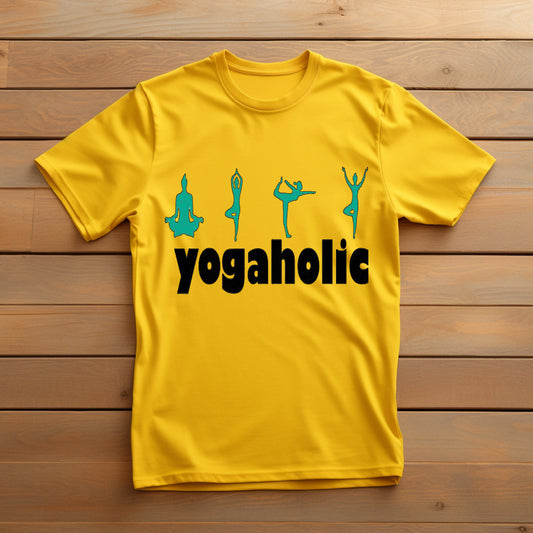  Bright yellow t-shirt displaying "yogaholic" in black text with four teal yoga silhouette poses above it, laid on a wooden surface.